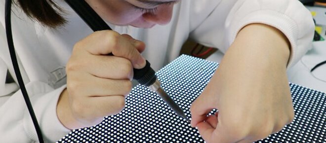 Technician repairing an LED display module onsite